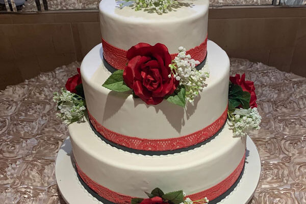 3 tiered wedding cake covered in roses