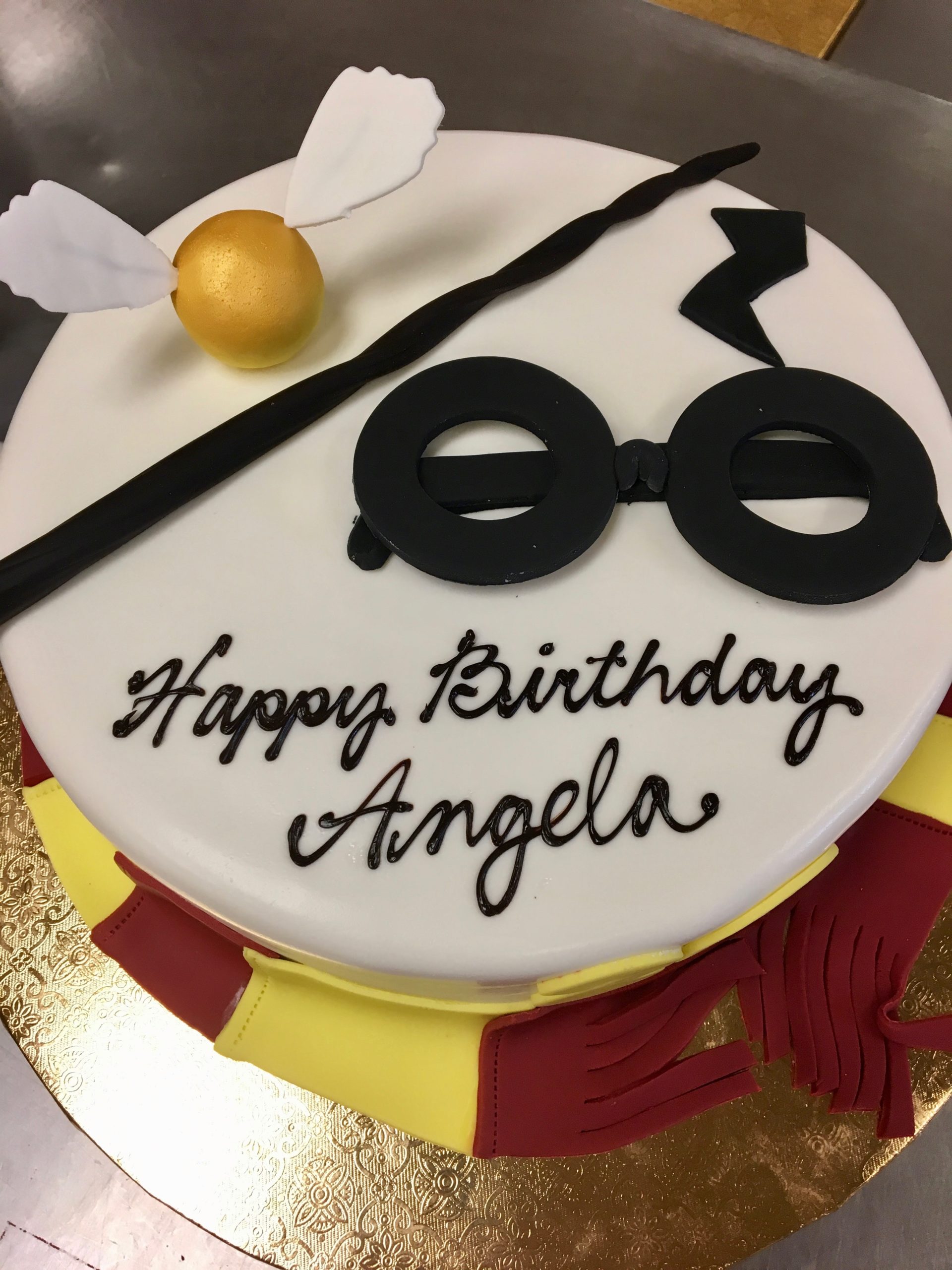 Harry Potter fondant cake with wand, scarf, glasses, and snitch