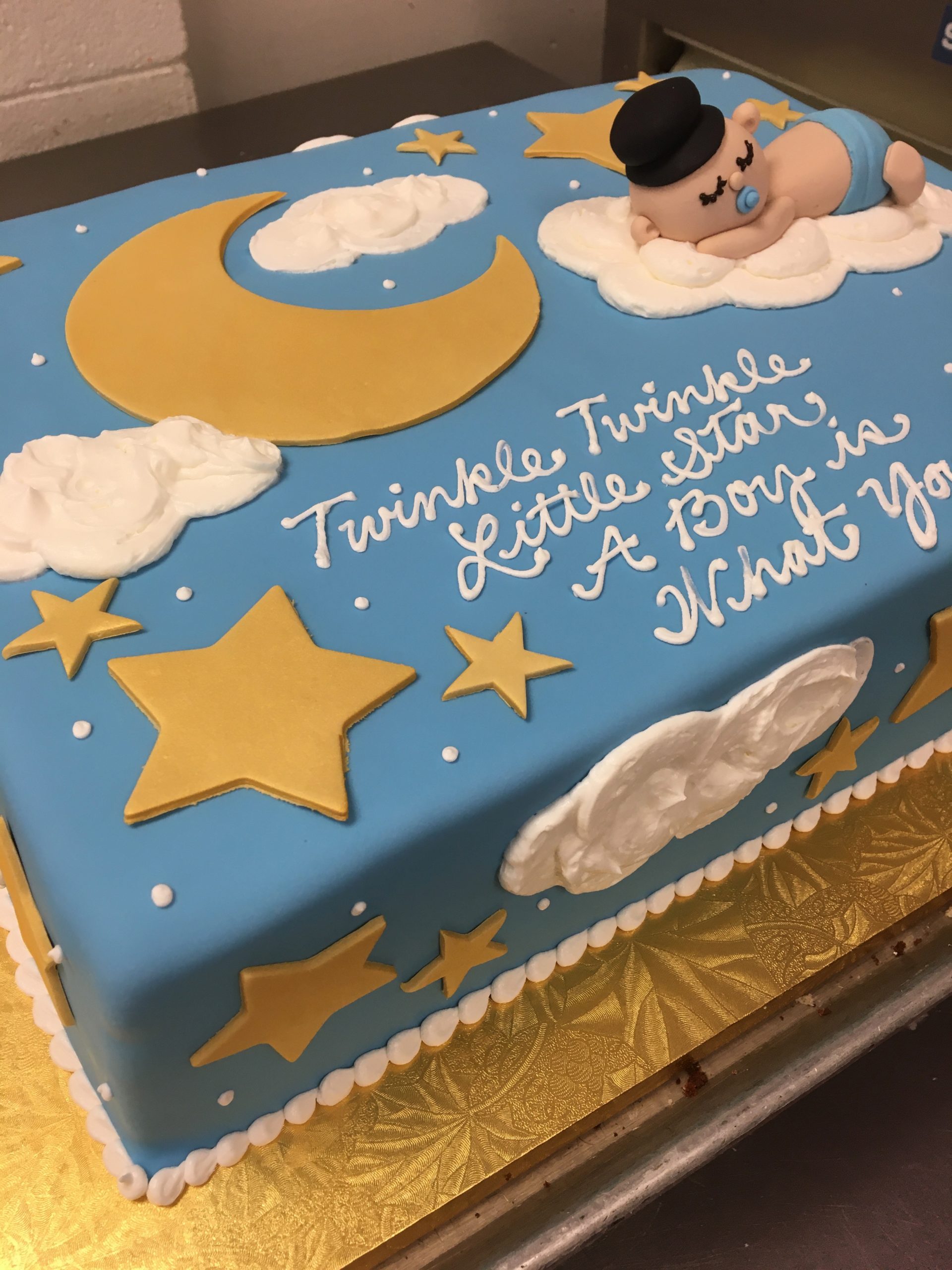 Blue fondant with gold stars, moon, clouds, and sculpted baby